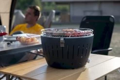 LotusGrill XL Hybrid Houtskoolbarbecue - Rood -Outwell Winkel lotusgrill in gebruik met toppy shirtje 2