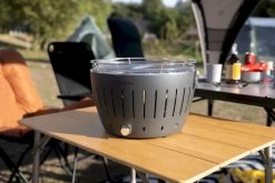 LotusGrill XL Hybrid Houtskoolbarbecue - Rood -Outwell Winkel lotusgrill in zon op tafel 3